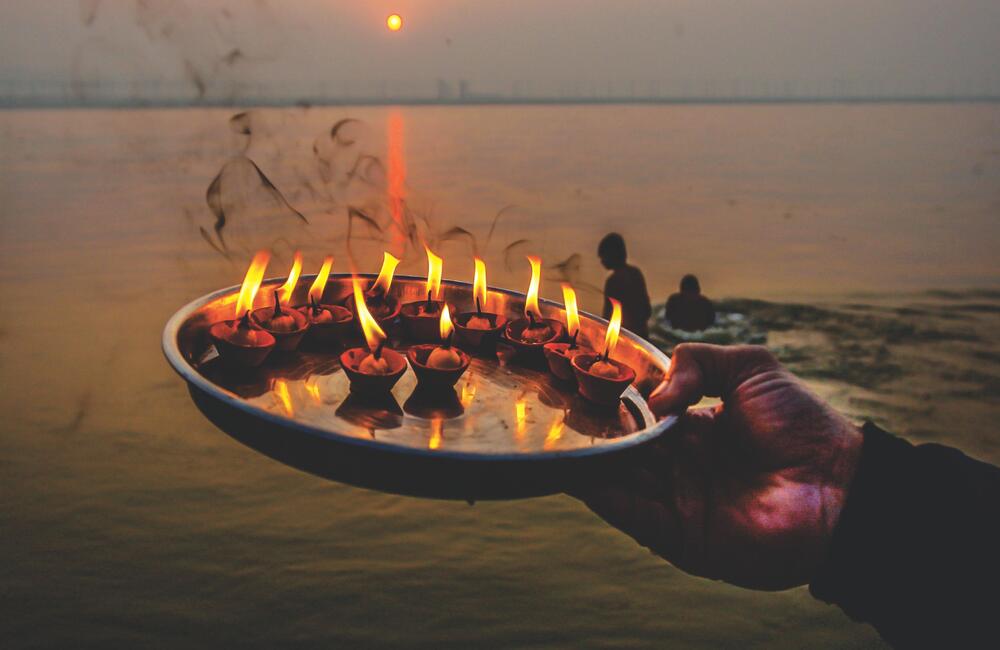 Morning aarti or puja at the banks of the sangam at the Prayag Kumbh, 2019. Countless people borne along by faith travel thousands of miles to arrive at the Kumbh Mela.