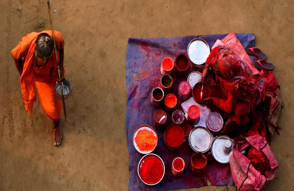 A sadhu passing by a vermillion seller at the Prayag Kumbh, 2019. Since medieval times the Mela has captured the imagination of historians, travellers, philosophers, writers, poets and artists. Photographer: Sunil Kumar.