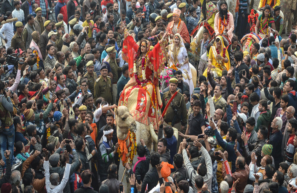 Peshwai of the Kinnar Akhara on camel back  at the Prayag Kumbh, 2019. The arrival of the various ascetic sects at the Kumbh for the shahi snan (royal bath) is marked by a procession of the akharas called the Peshwai on chariots and horses. In 2019 the Kinnar Akhara (transgender ascetic sect) was allowed to take out a Peshwai by the Akhil Bharatiya Akhara Parishad and it became quite a special and colourful occasion full of music, dancing and flowers. 