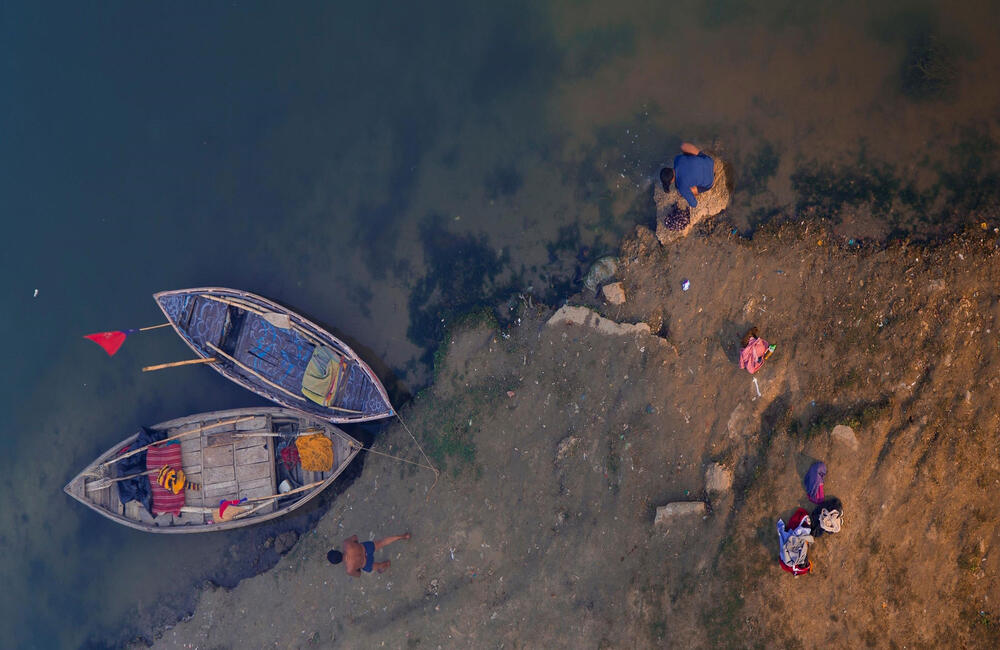 Aerial shot of ritual bathers at the Prayag Kumbh, 2019. The Kumbh mela is a fifty-five day festival where it seems as if the whole of humanity has landed on the shores of the sacred rivers. The pilgrims gather at these sacred ghats (banks) to take ritual baths.  This act is believed to cleanse a person of his or her sins and deliver them from the cycle of birth and death. Photographer: Satish Chalotra.  